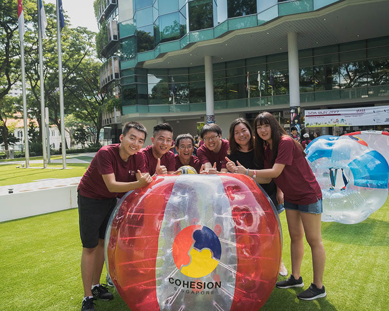 Bubble Soccer group smiling beside the inflatable suits before the session starts