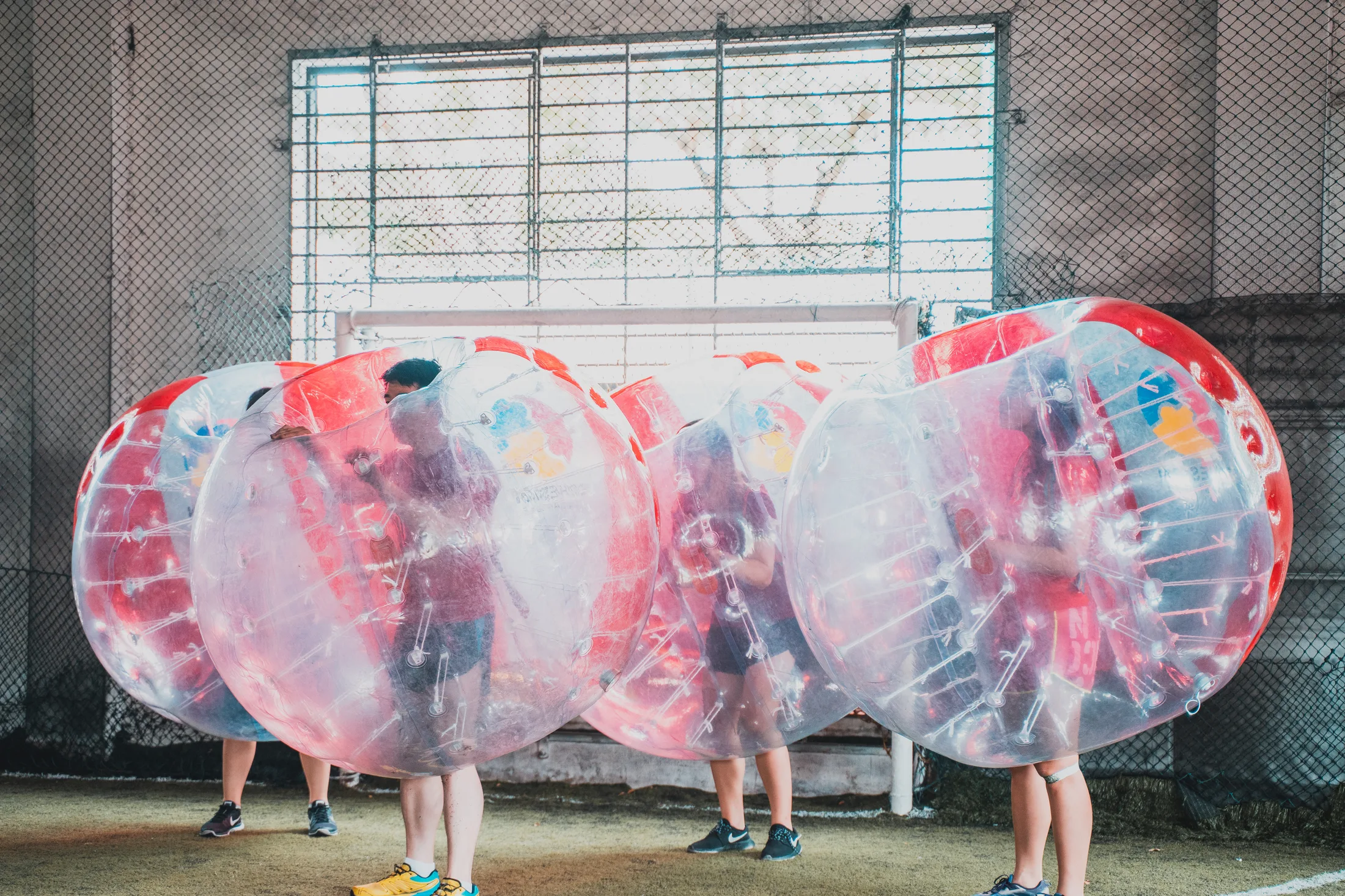 Bubble Soccer players lined up in inflatable suits on an indoor turf pitch