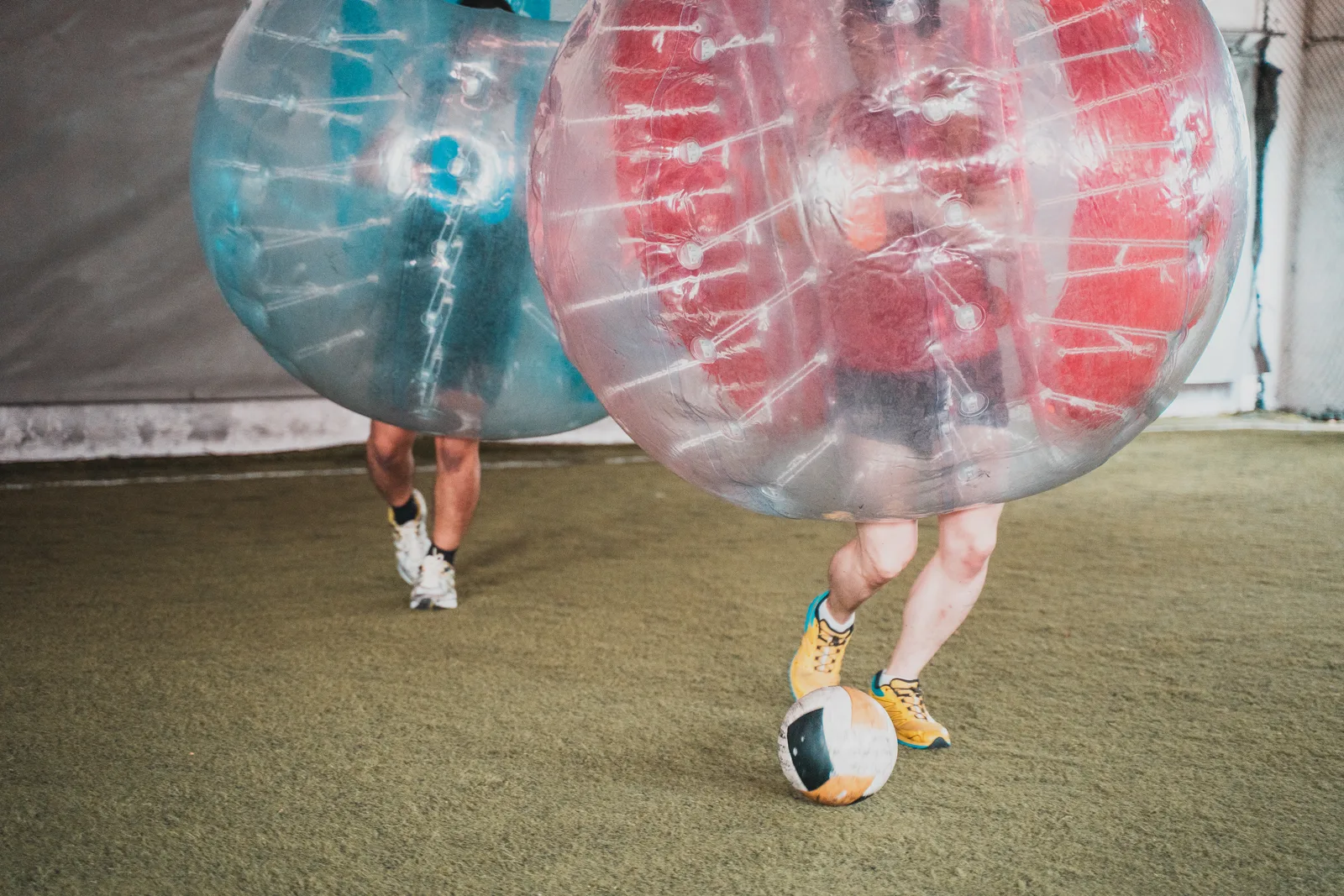Bubble Soccer players rotating through a lively youth-style round on the indoor turf