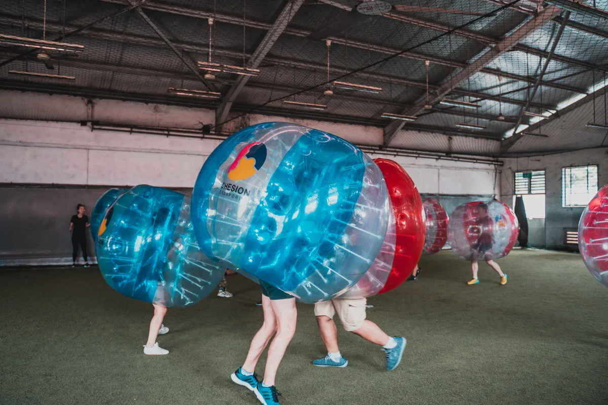Wide Bubble Soccer round with multiple players spread across the indoor turf